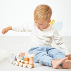Child playing with Janod Pull along snail on a neutral background