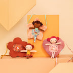 Lilliputiens Anna doll with star bag styled with different Lilliputiens dolls on an orange and peach background