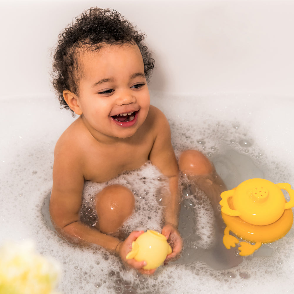 Child in a bath tub playing with the Lilliputiens bath pyramid Gaspard