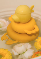 Lilliputiens bath pyramid Gaspard floating on water with yellow and white flowers