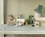 Maileg Little Brother Mouse in matchbox with polka dot pyjamas styled with other toy mice, a plush toy and doll furniture (not included)