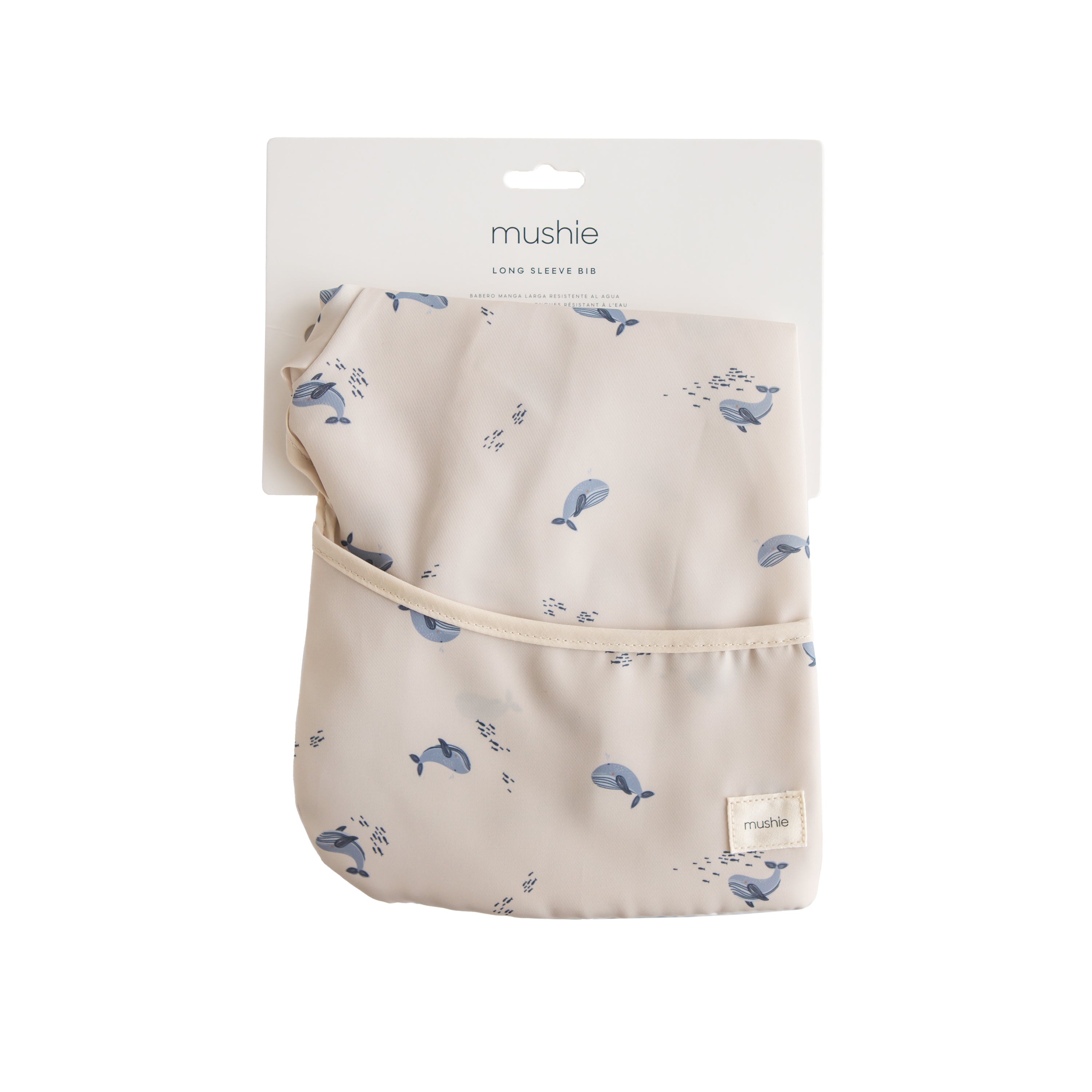 Mushie long sleeve bib in Whales print in original packaging on a white background