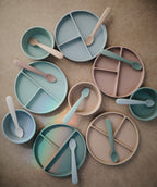 Mushie first feeding baby spoons 2-pack in Blush and Shifting sand styled with baby feeding accessories