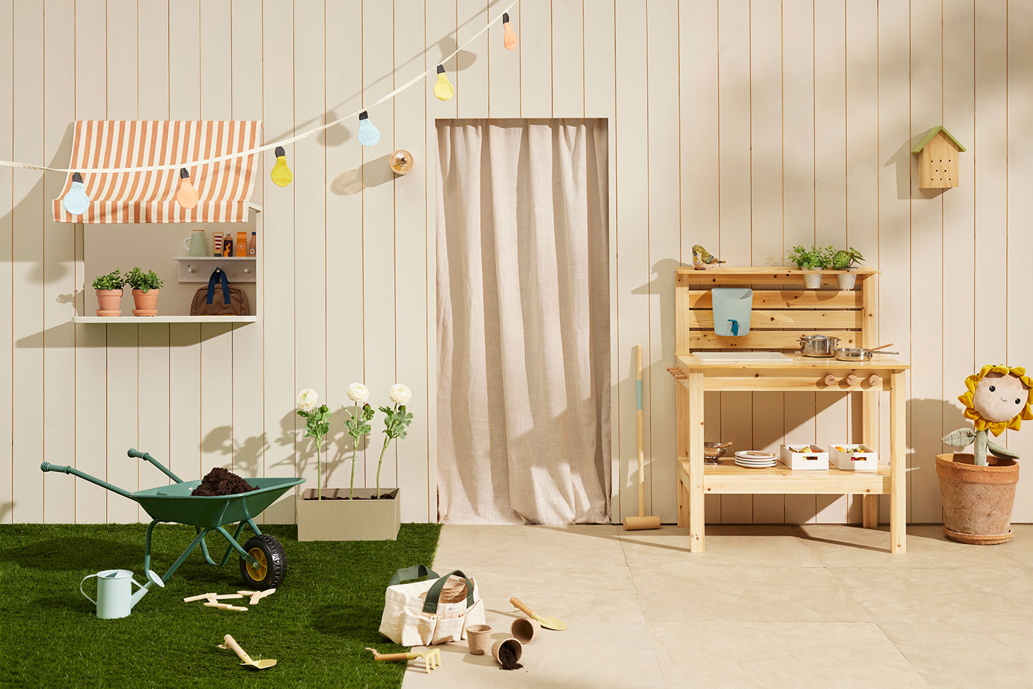 Children's playroom with a garden-themed objects and a Kid's Concept gardening tool set for kids on a grass-like floor