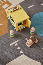 Kids Concept wooden toy ambulance on a road mat with small figures (included) around it