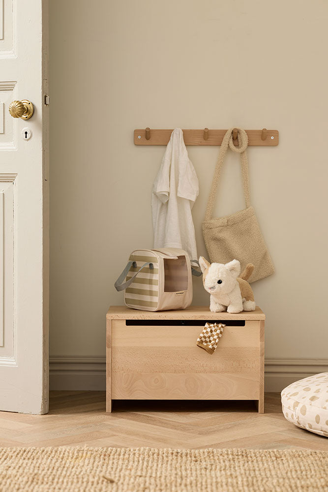 Kids Concept toy cat with carrier bag in a room with a neutral color scheme