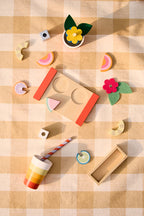 Kids Concept wooden drink play set on a checkered fabric background