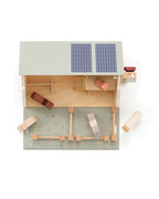 Top view of a Kid's Concept wooden farmhouse toy on a white background
