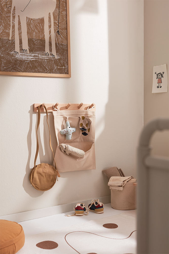 Kids Concept wall hook board with a bag organizer, hanging bags and children’s shoes in a kids room with rug and wall art