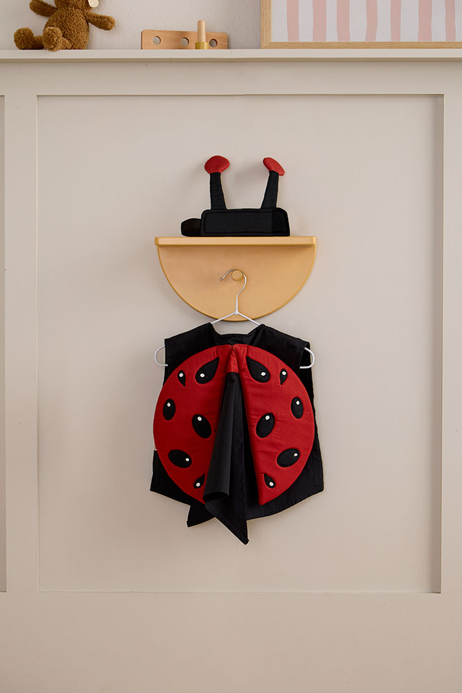 Kid's Concept ladybug dress-up costume hanging on a neutral wall