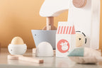 Close-up of a Kid's Concept wooden mixer set on an orange background