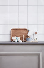 Kitchen counter with a wooden tray, Kid's Concept wooden mixer set on a white tiled wall