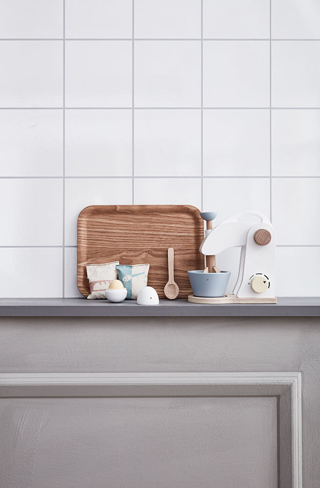 Kitchen counter with a wooden tray, Kid's Concept wooden mixer set on a white tiled wall