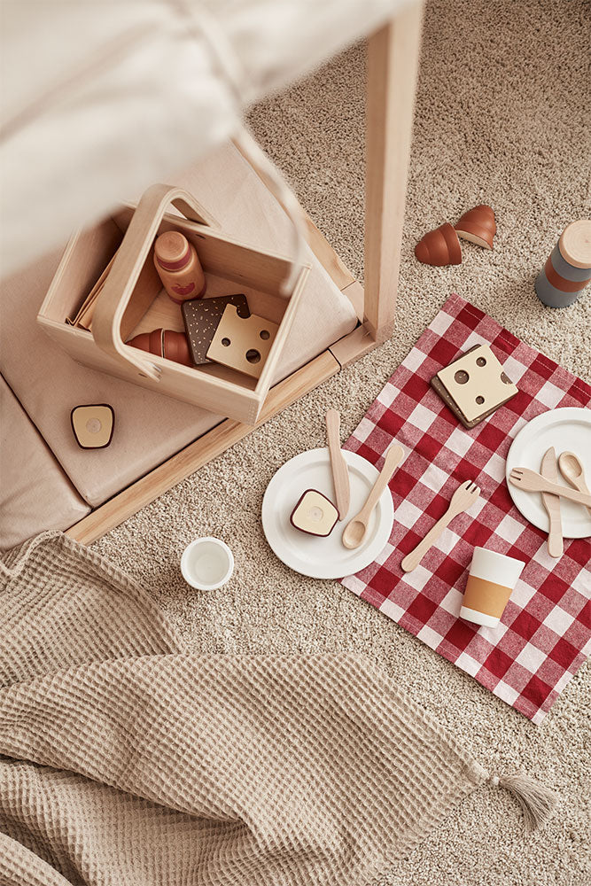 Kid's Concept picnic play set styled with a beige blanket on a beige carpet