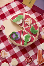 Kids concept pizza play kit with various toppings on a red and white checkered tablecloth