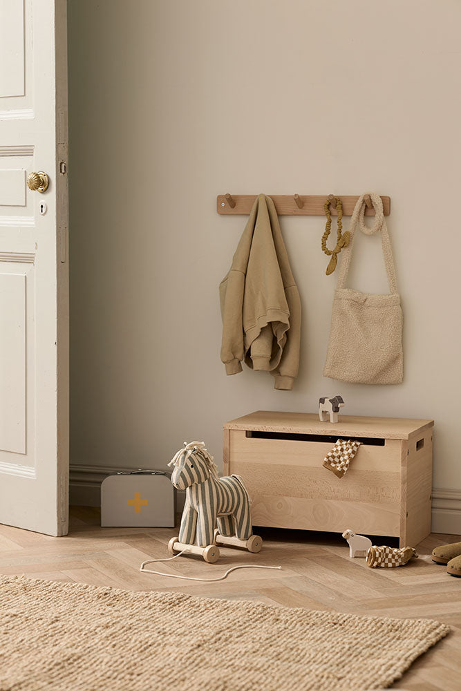 Children's room with a Kid's Concept pull-along horse Sam, wooden toy chest and hanging clothes