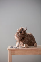 Kid's Concept pull-along moose toy on a wooden table against a gray wall