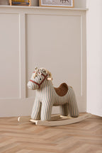 Kid's Concept rocking horse Sam on a wooden floor with a neutral wall background