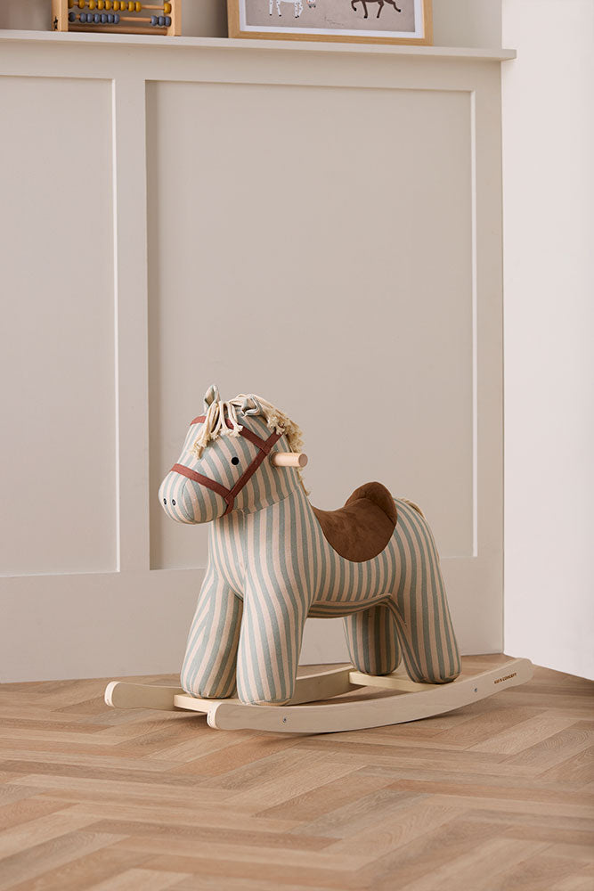 Kid's Concept rocking horse Sam on a wooden floor with a neutral wall background