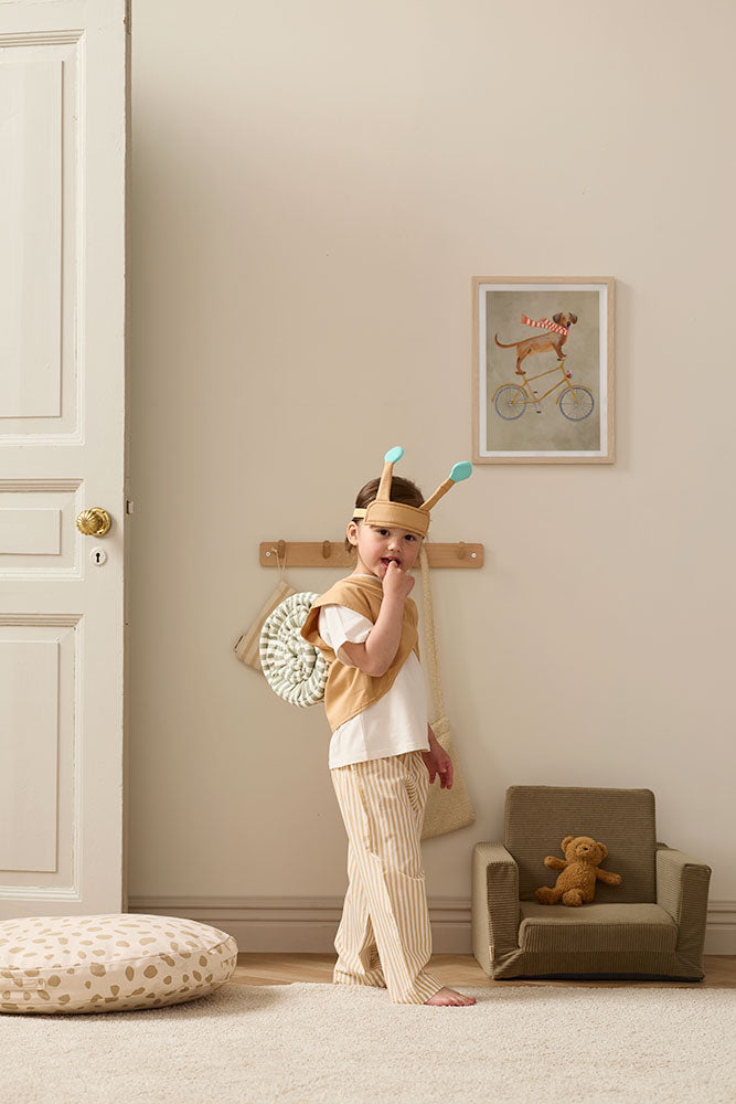 Child in a Kid's Concept snail dress-up costume standing in a room with a teddy bear (not included) and small chair
