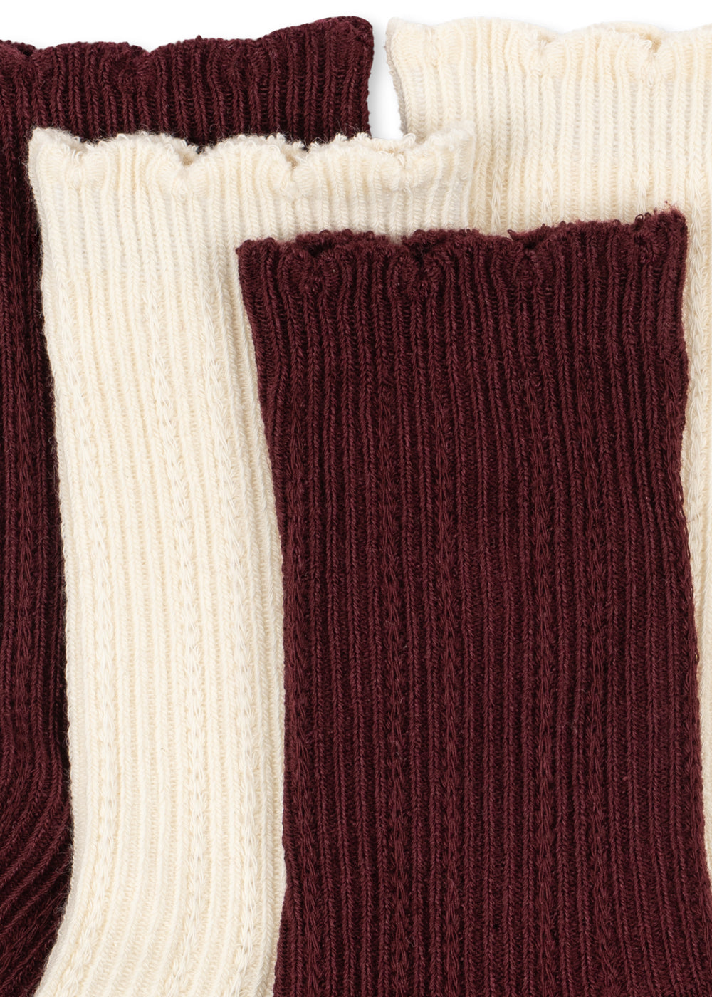 Close-up of the Konges Sløjd Bow 2-pack Pointelle Socks in Bordeaux/ Off white on a white background.