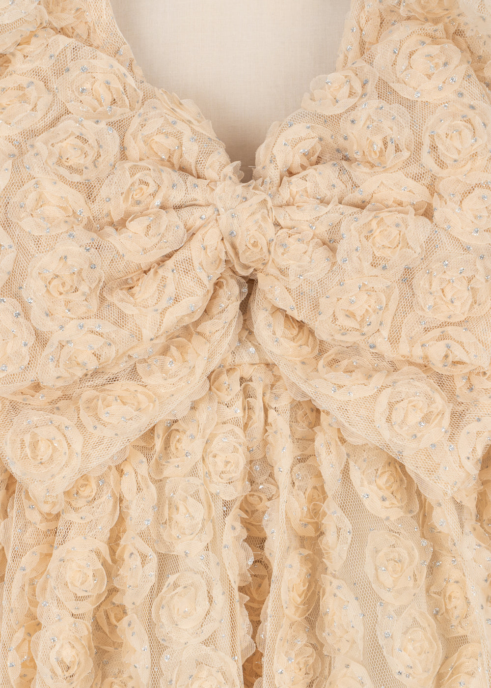 Close-up of the Konges Sløjd Ally dress in Sandshell on a neutral background