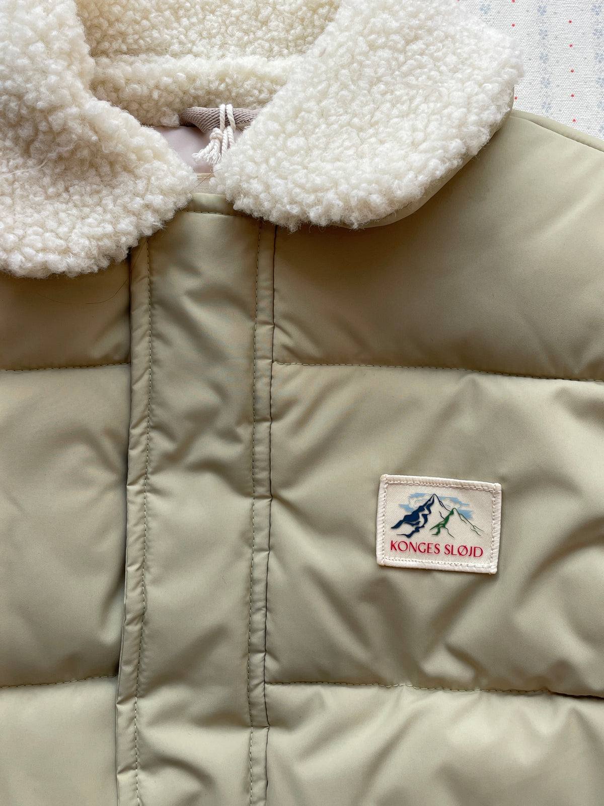 Close-up of the Konges Sløjd Alpi Collar jacket in Pale Olive Green
