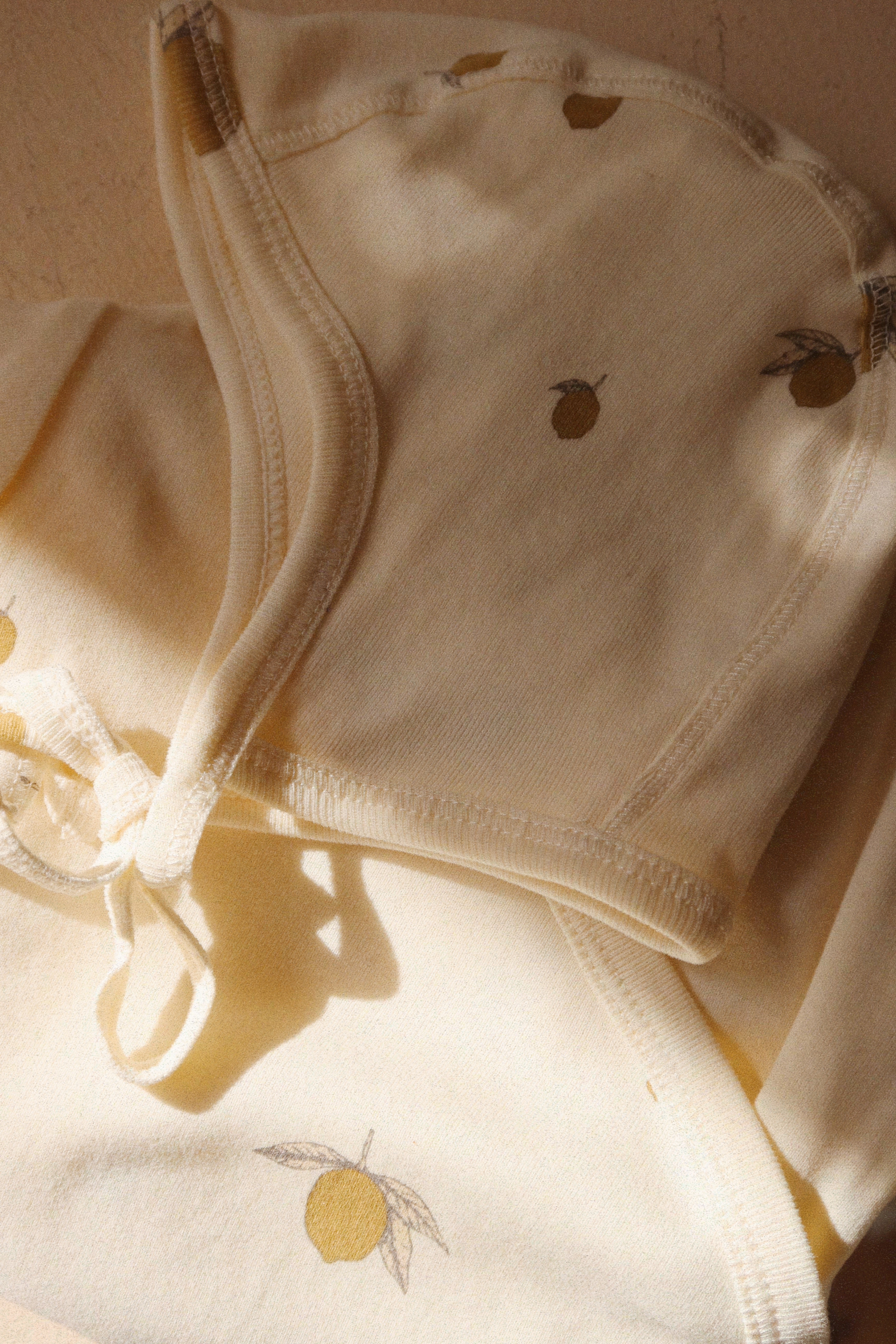 Close-up of Konges Sløjd Baby helmet in Lemon on a neutral background