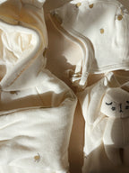 Close-up of Konges Sløjd Baby helmet in Lemon with a small plush toy (not included) on a neutral background