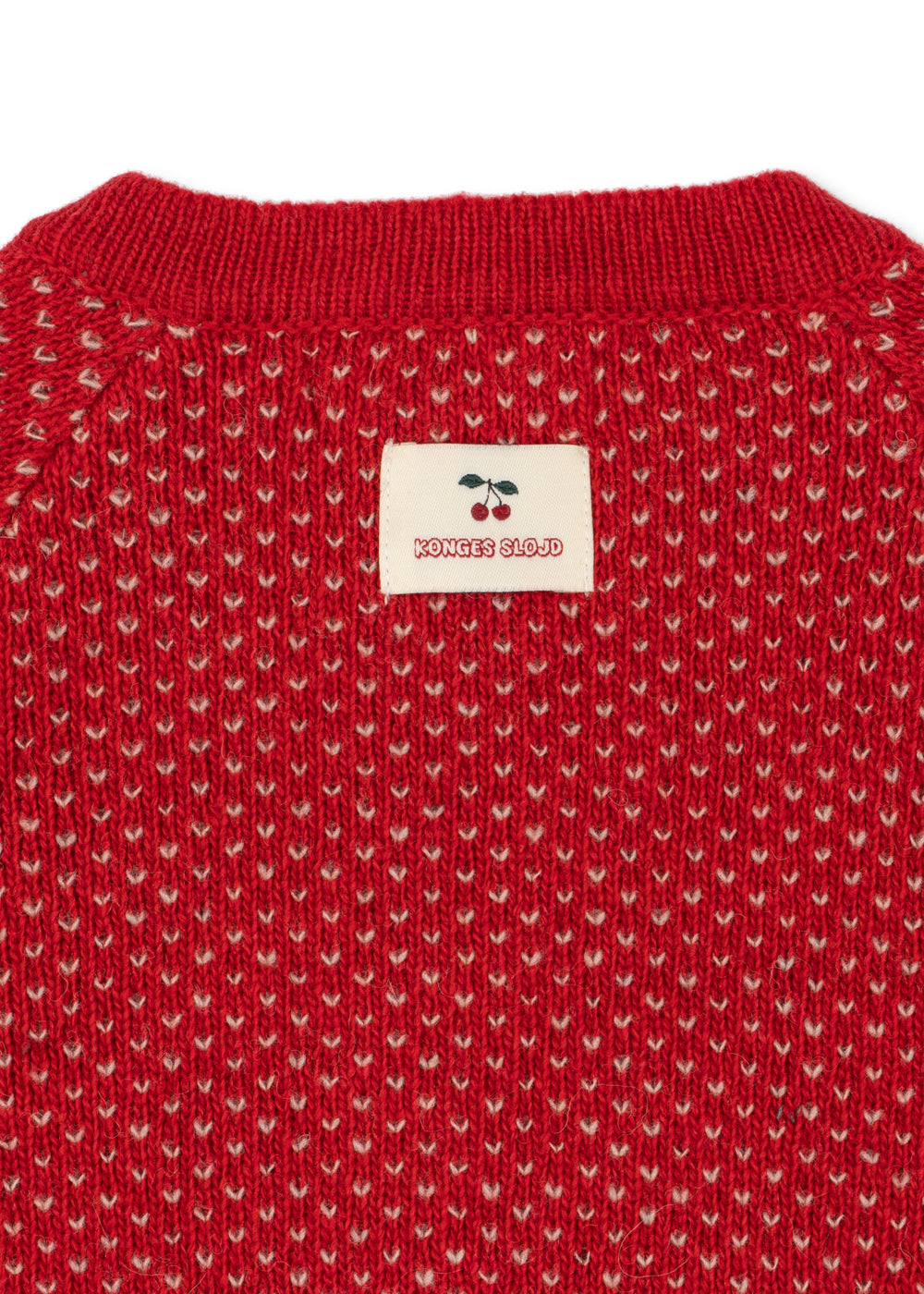 Close-u of the Konges Sløjd Belou cardigan in Cat Rouge on a white background.