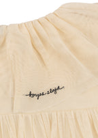 Close-up of the Konges Sløjd Bow Dress in Parchment on a white background.