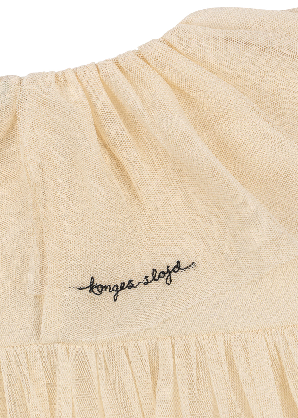 Close-up of the Konges Sløjd Bow Dress in Parchment on a white background.