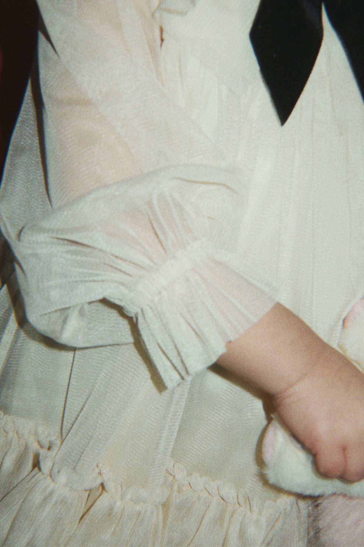 Close-up of a child wearing the Konges Sløjd Bow Dress in Parchment.