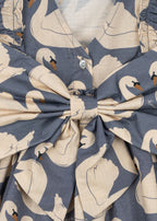 Close-up of the Konges Sløjd Evia long-sleeve bow dress in Swan print on a white background.