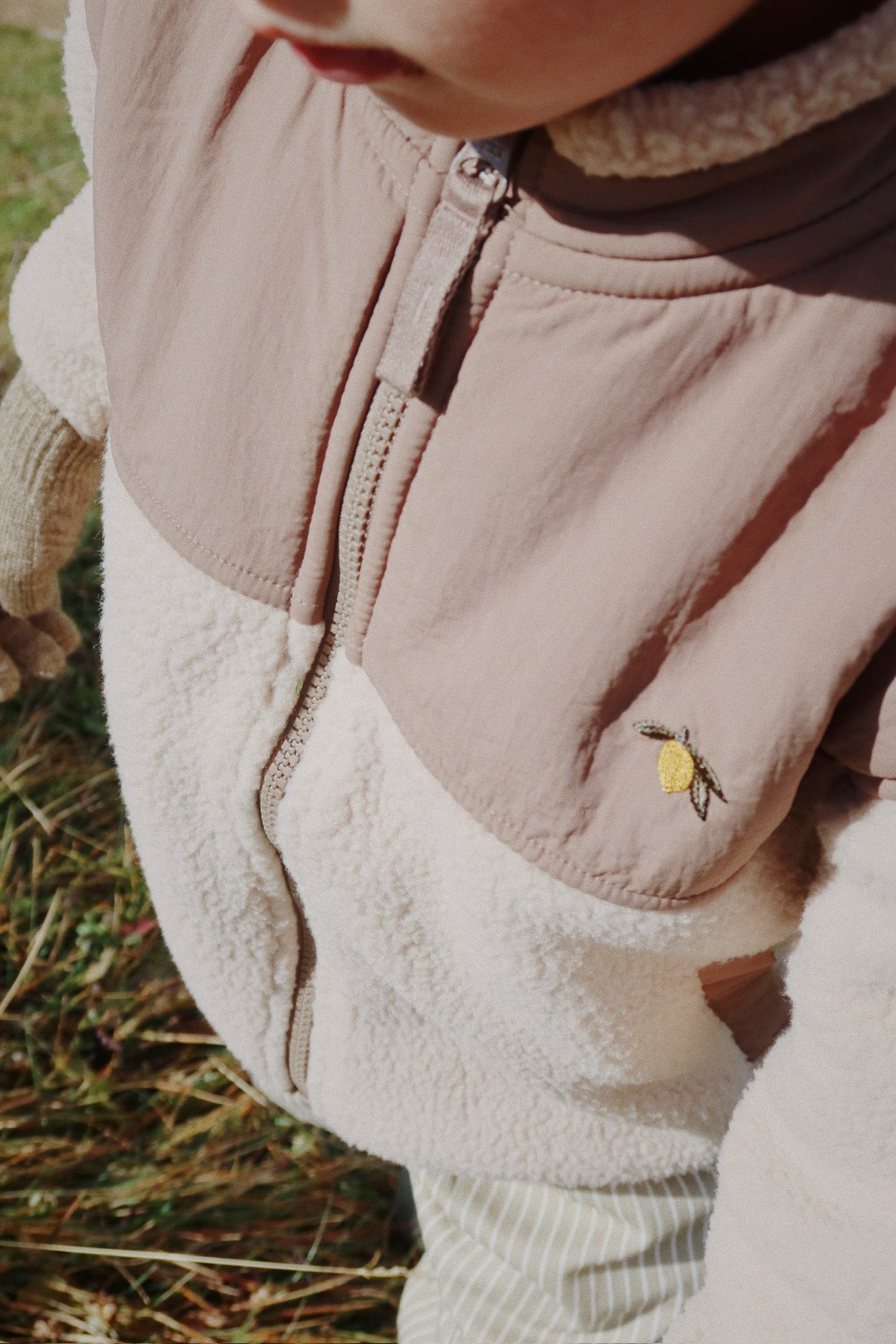 Close-up of a child wearing a Konges Sløjd Flynn fleece jacket in Oxford Tan