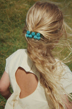Child wearing a Konges Sløjd Hearly dress in Sea mist in a grassy field