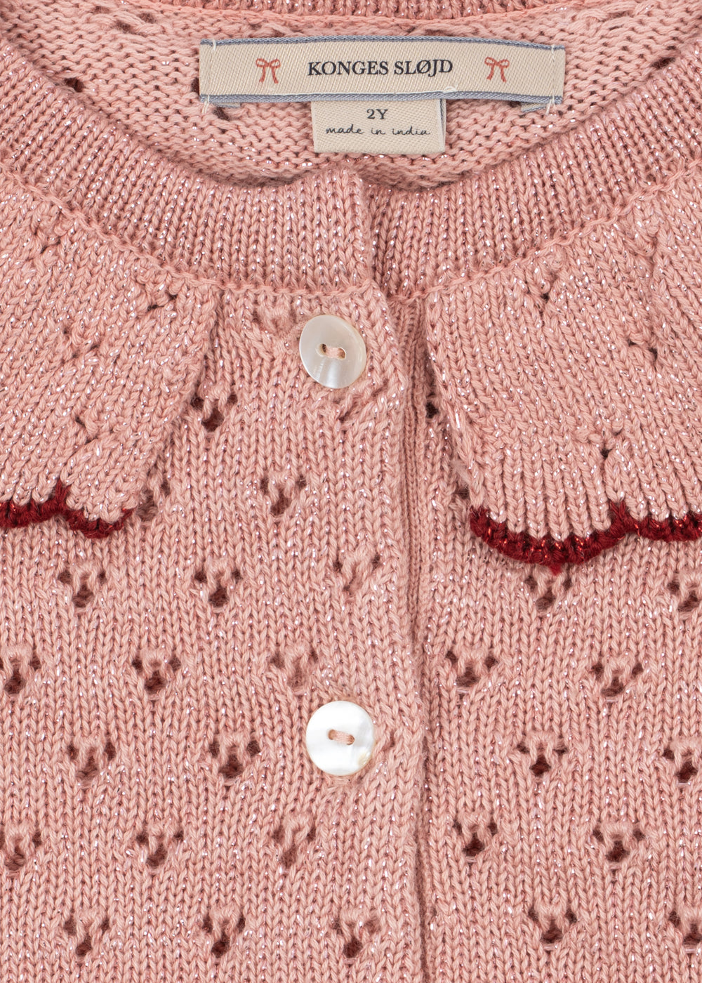 Close-up of the Konges Sløjd Holiday Cardigan in Mellow Rose on a white background.