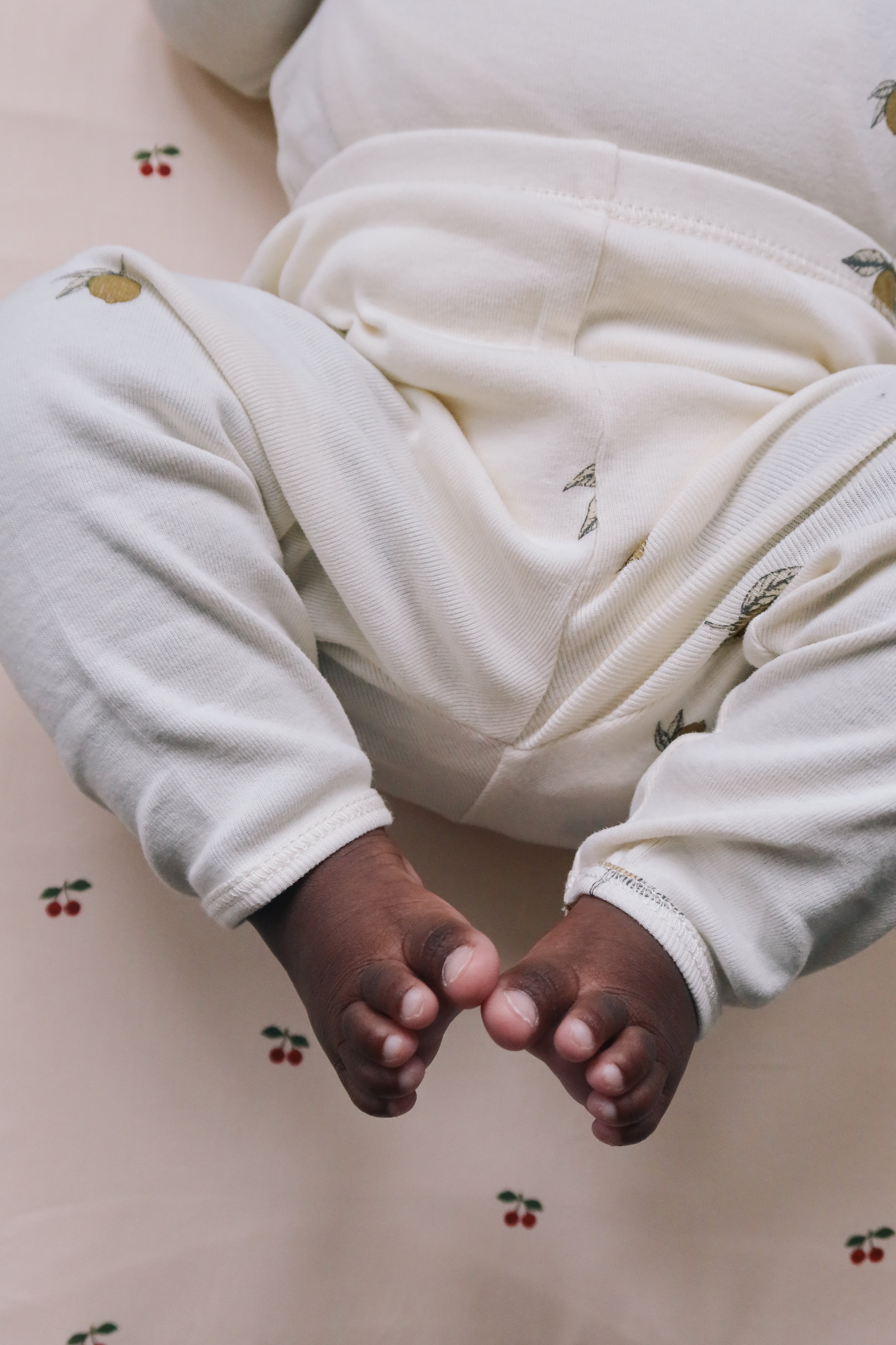 Close-up of a baby's feet in Konges Sløjd Leggings in Lemon,on a light-colored surface 