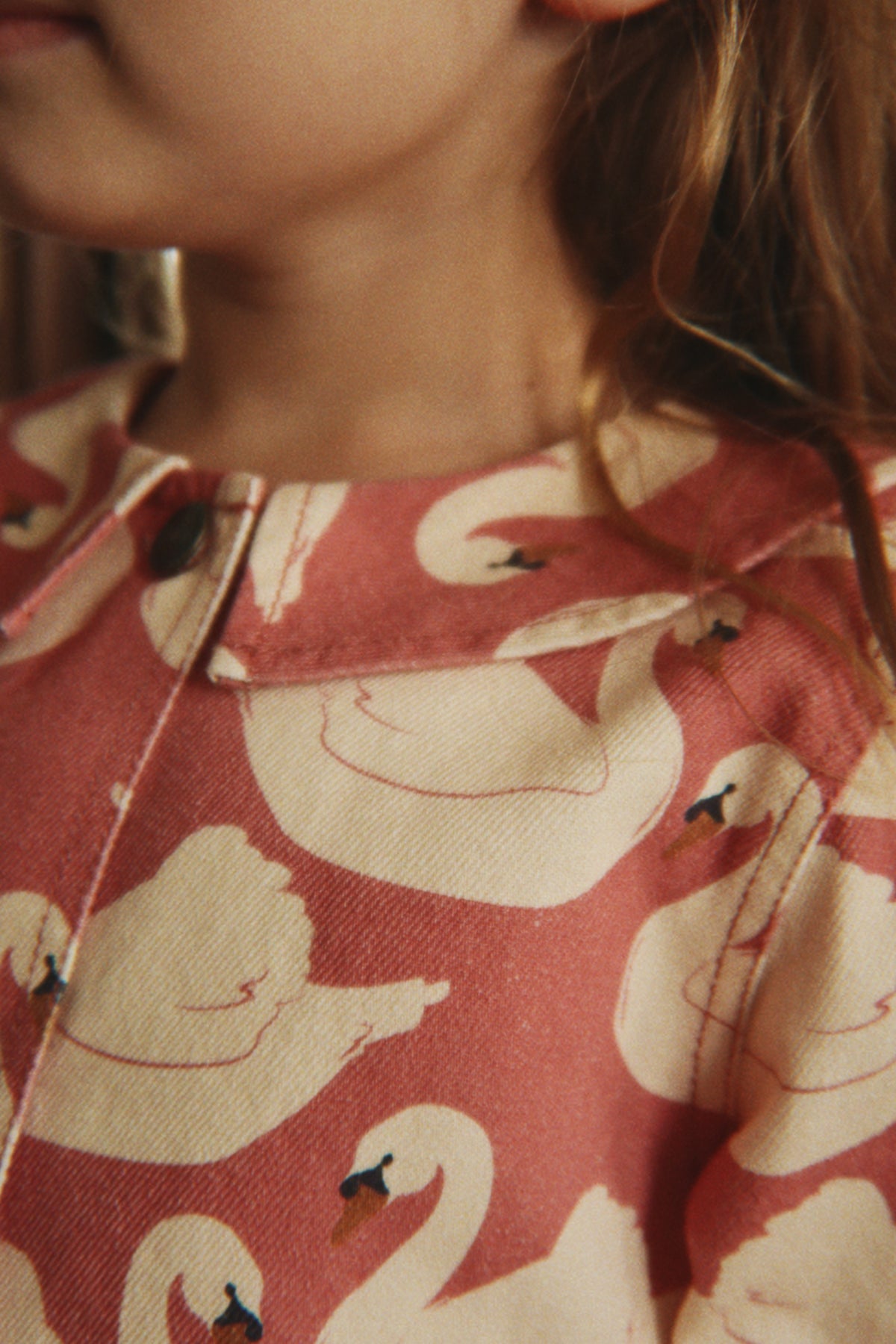Close-up of a child wearing the Konges Sløjd Magot Frill Jacket in Swan Rose.