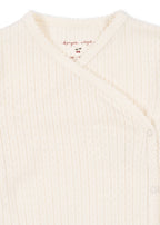 Close-up of Konges Sløjd Minnie newborn body in Antique white fabric and collar