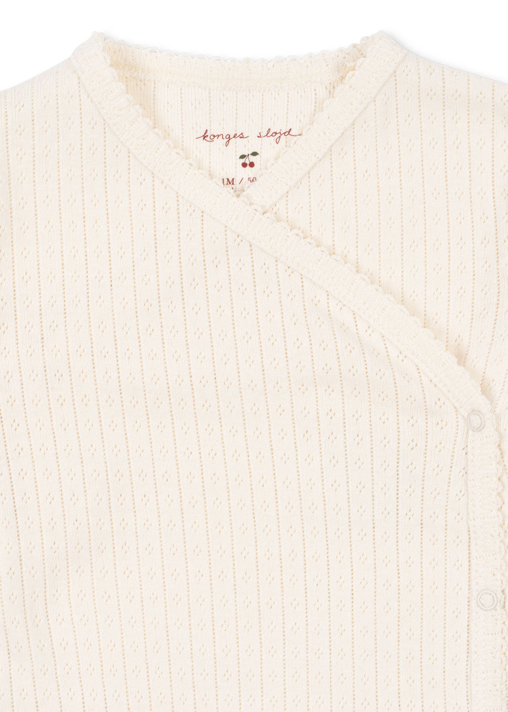 Close-up of Konges Sløjd Minnie newborn body in Antique white fabric and collar