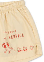 Close-up of a Konges Sløjd Pomio short swim shorts in banana crepe on a white background