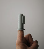 Mushie finger toothbrush in Cambridge blue on a neutral background