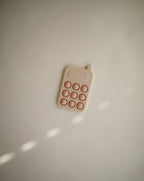 Mushie press toy phone in Blush on a beige background