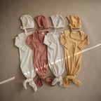 Mushie ribbed baby bonnet in Ivory styled with Mushie ribbed baby bonnets with matching baby gowns in different colours