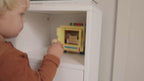 Child playing with a Kids Concept wooden toy ambulance in a neutral styled living room