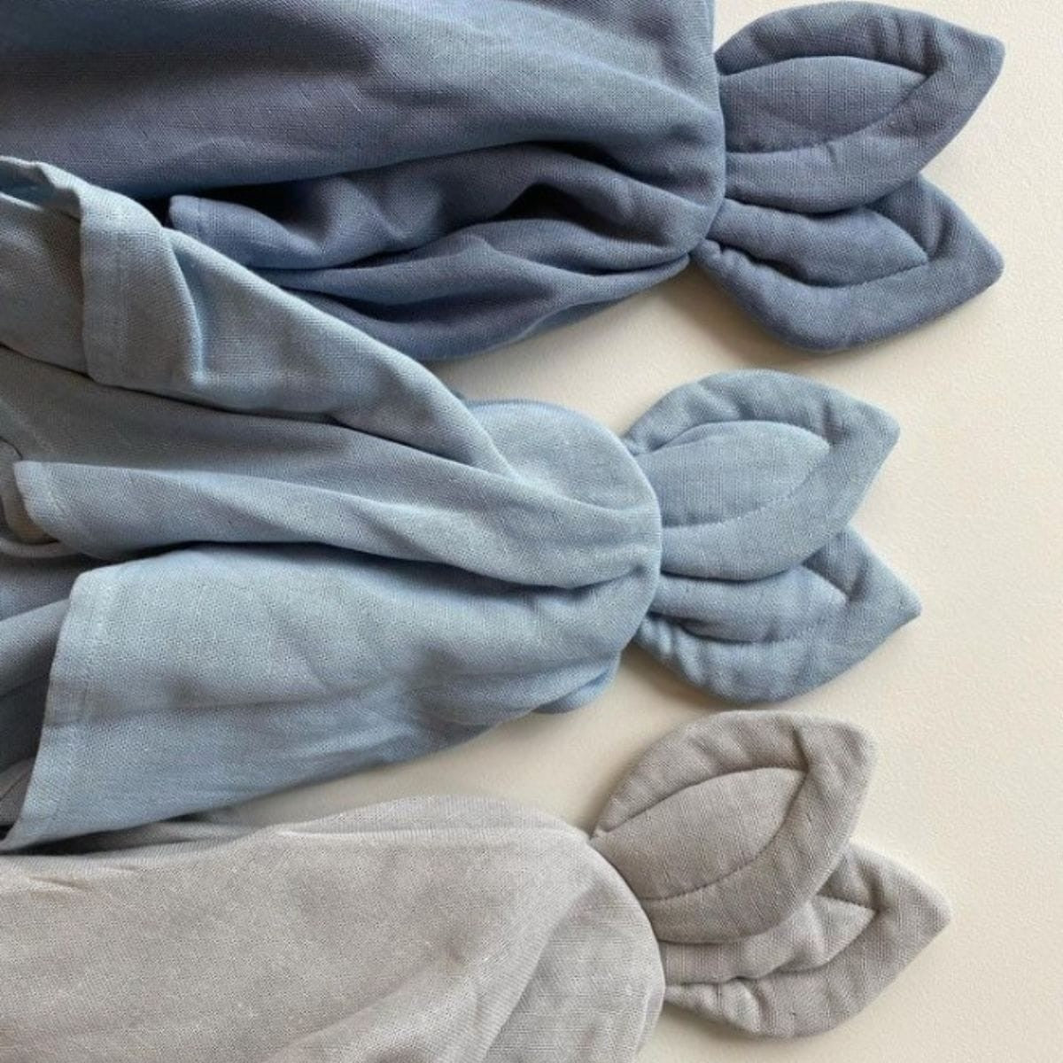 Sage Copenhagen Snoppa cuddle cloth in Moonlight blue with other cuddle cloths in different colors on a neutral background